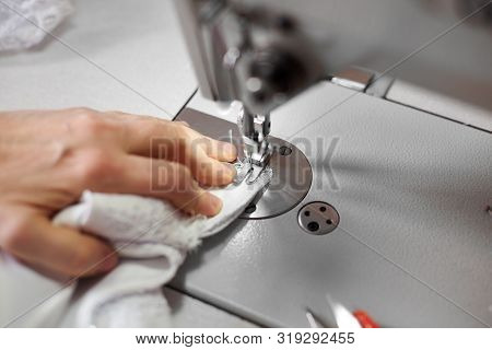 Seamstress Hand Stitching White Fabric On Professional Machine At Workplace. Footplate Of Sewing Mac