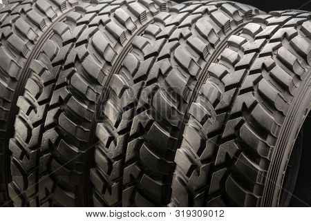 Four Off-road Tires On Black Background. Close Up.
