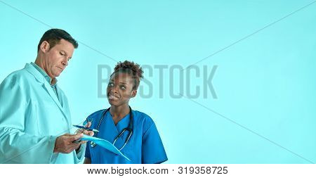 Doctor Explains To The Nurse Treatment Pllan For A Patient, Two Professionals, Seinor White Male And