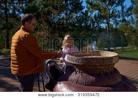 Harrington, Qc, Canada - September 23, 2018: In A Buddhist Temple, Tourists Lit Incense Sticks With 