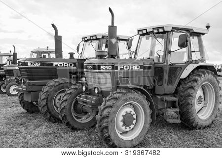 Haselbury Plucknett.somerset.united Kingdom.august 18th 2019.a Row Of Classic Ford Tractors Are Park