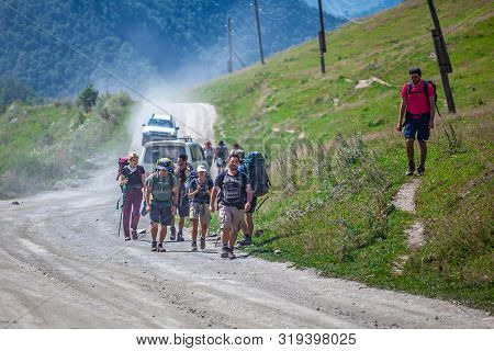 Ushguli, Georgia - 09.08.2019: Tourists With Backbacks Traveling In The Rural Road Of Ushguli, Svane