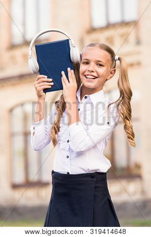 Elearning And Modern Methods. Girl Cute Schoolgirl Hold Book And Headphones. Knowledge Assimilate Be