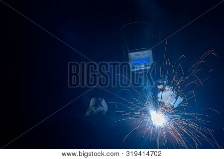 Professional Welder And Mask Welding Metal Pipe On The Industrial Table.a Welder Is A Tradesperson W