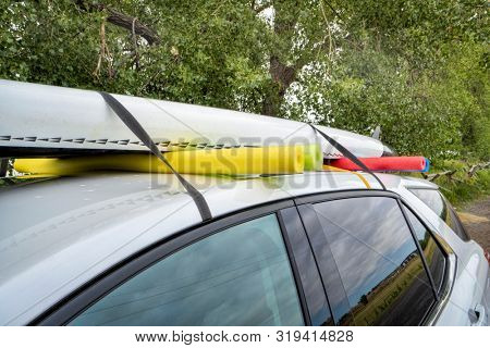 stand up paddleboard on a rental car roof, improvised fitting with straps and swimming pool foam noodles