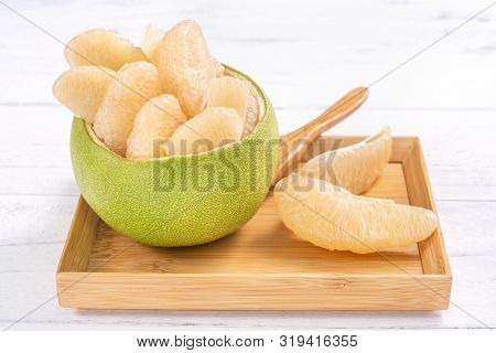 Fresh Peeled Pomelo, Grapefruit, Shaddock With Green Leaf On Bright Wooden Plank Table. Seasonal Fru