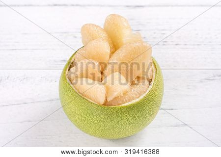 Fresh Peeled Pomelo, Grapefruit, Shaddock With Green Leaf On Bright Wooden Plank Table. Seasonal Fru