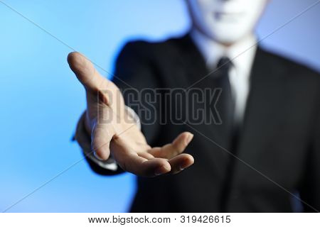 Politician Or Businessman Wearing Black Suit And White Mask Giving His Hand (meaning Of Blackmail Or