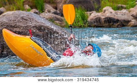 Myhiya, Ukraine - August 17, 2019: Playboating. A Man Sitting In A Kayak With Oars In His Hands Perf