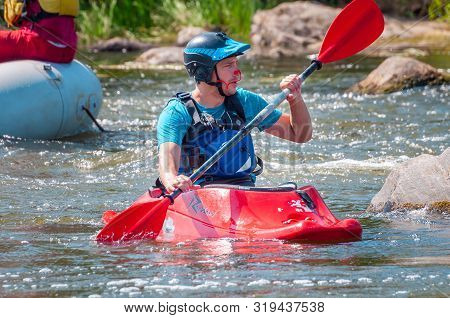Myhiya, Ukraine - August 17, 2019: Playboating. A Man Sitting In A Kayak With Oars In His Hands Perf