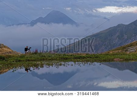 Saint-sorlin, France, August 10, 2019 : Photographer Shoots A Landscape Of A Mountain Lake In The Fi