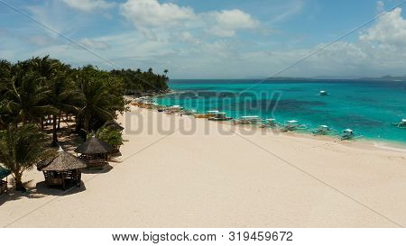 Beach With Tourists And Boats On A Tropical Island, Clear Blue Water. Daco Island, Philippines. Summ
