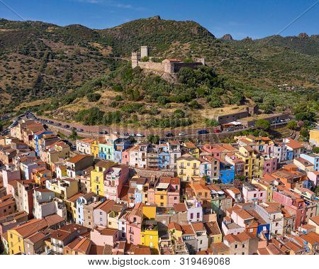 Castle Over Medieval City Of Bosa, Sardinia, Italy. Characteristic Colorful Houses At Slope Of The C
