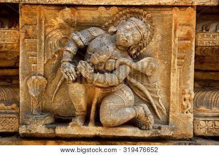 Close-up Of Stone Sculpture Of Bean Player On Wall At Rayara Gopura In Melukote, Mandya District, Ka