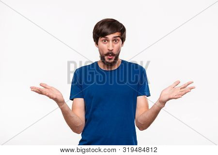 Good Looking Brunet Man In A Blue Shirt With Beard And Mostaches Shrugging His Shoulders Being Surpr