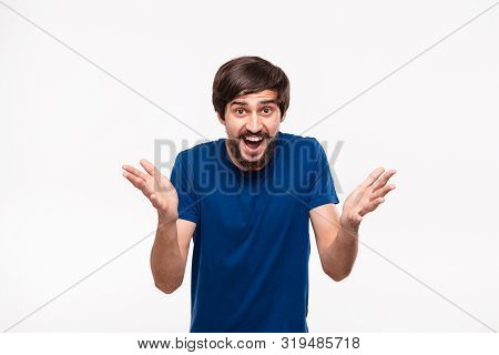 Good Looking Brunet Man In A Blue Shirt With Beard And Mostaches Shrugging His Shoulders Being Surpr