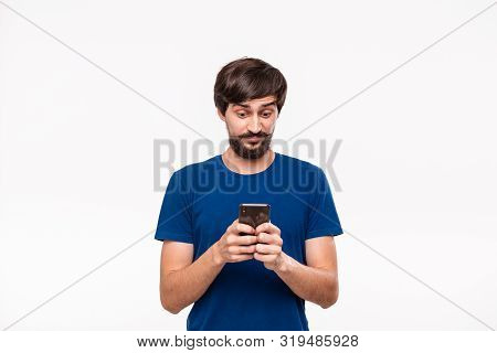 Good Looking Brunet Man In A Blue Shirt With Beard And Mostaches Shocked Looking At The Screen Of A 