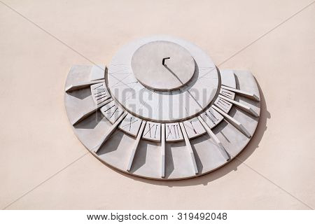 Old Solar Clock On A White Wall, Close Up. Old Fashioned Sun Dial On A Stone Wall Isolated On White,