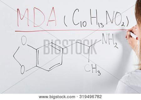 Cropped View Of Woman Writing Mda On White Board