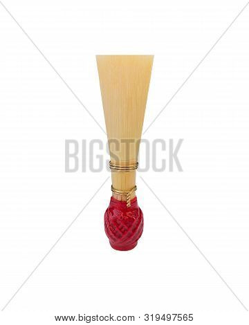 Double Reed For Bassoon Rewound With Red Thread On A White Background. Element For Wind Musical Inst