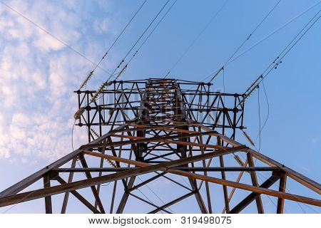 High Voltage Tower Against The Blue Sky. Electric Tower And Cables. Electrical Linear Insulator. Bot