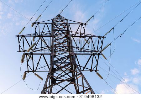 High Voltage Tower Against The Blue Sky. Electric Tower And Cables. Electrical Linear Insulator. Bot