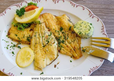 Fried Plaice Fillet With Herb Butter And Lemon On A Plate, Typical Food In Northern Germany At The C
