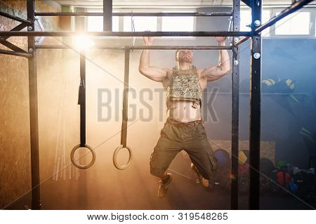 Attractive Fitness Guy Doing Pull-ups On The Crossbar During Training In The Modern Gym. Close Up Sh