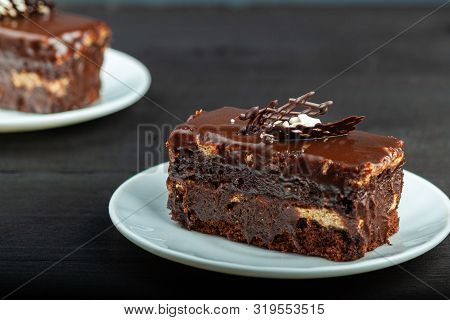 Dish With A Slice Of Chocolate Cake Stands On A Wooden Table