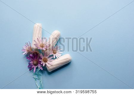 Menstrual Tampons With Pink Flowers On Blue Background. Menstruation Time. Hygiene And Protection. P