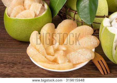 Fresh Peeled Pomelo, Grapefruit, Shaddock With Green Leaves On Dark Wooden Plank Table. Seasonal Fru