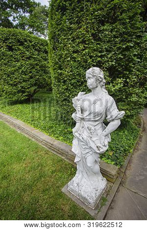 Grec Inspire Statue In Formal Green Garden
