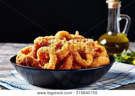 Crispy Calamari Rings, Deep-fried Breaded Squid Rings Served With Tomato Sauce In A Black Bowl On An