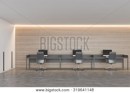 Interior Of Modern Open Space Office With White And Wooden Walls, Concrete Floor And Row Of Gray Com