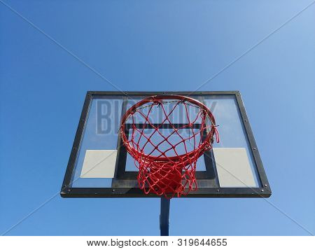 Front Image Of Basketball Basket Ring From The Bottom With Clear Blue Sky On Background