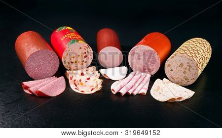 Traditional German cold cuts sausages as closeup on a black board with copy space 