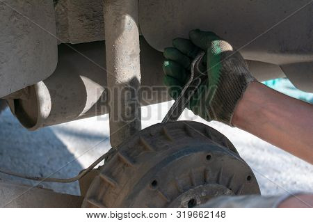 Hands In Defense Gloves Mechanics To Repair The Suspension On The Car. Work With A Wrench. Self-repa