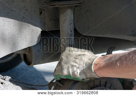 Hands In Defense Gloves Mechanics To Repair The Suspension On The Car. Work With A Wrench. Self-repa