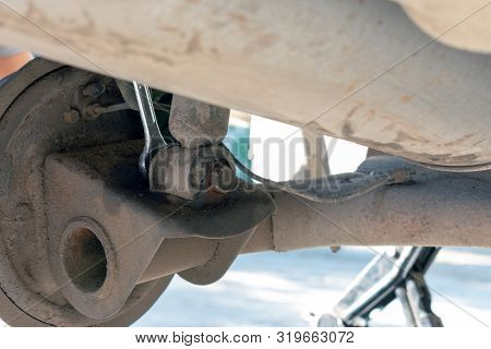 Hands In Defense Gloves Mechanics To Repair The Suspension On The Car. Work With A Wrench. Self-repa