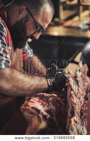 Chef cutting beef carcass in a restaurant