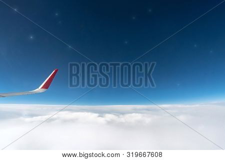 Airplane Window View To Cloudy Sky And Stars. Beautiful Sky From Aircraft Cabin. Flying Without Inci