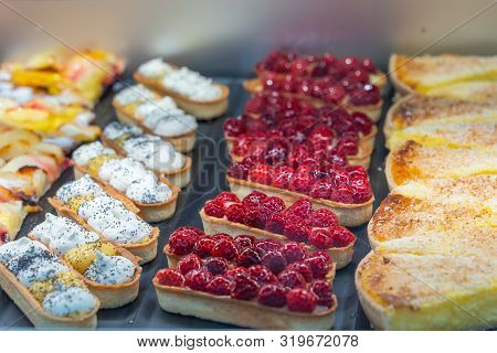 Colorful Icing Raspberry Tart And Fruit Tart Displayed In Patisserie