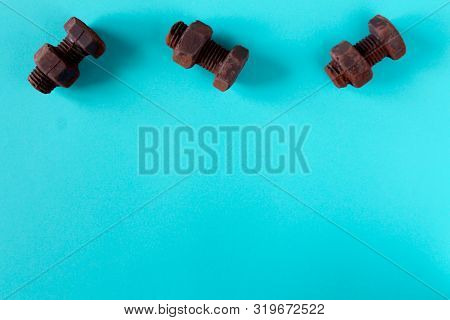 Rusty Bolts And Nuts Made Of Chocolate Isolated On Sky Blue Background. Mechanic Gearing Background.