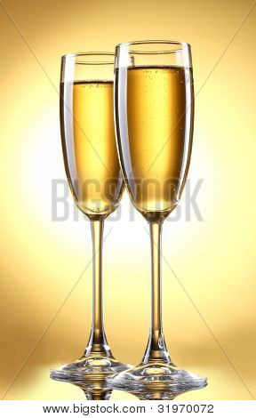 glas champagne på gul baggrund