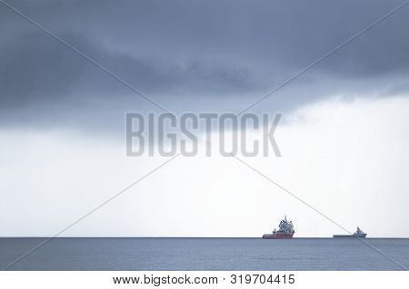 Ship On Horizon Under Dark Grey Sky During A Sea Storm