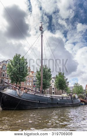 Amsterdam, The Netherlands - July 1, 2019: Avance Sailing Houseboat To Live In On Canal Under Heavy 