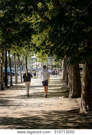 Lisbon, Portugal - 9 August 2019: Couple Riding A Lime S Electric Scooter Along Avenida Da Liberdade