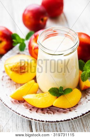 Yogurt With Fresh Nectarines On A White Wooden Table