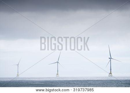 Wind turbines at electric power farm in the North Sea in Aberdeen for renewable energy production an