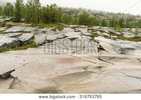 Rock Art In Alta Fjord, Norway. Ancient Symbols, Real Drawing,  Texture In Stone. Red Ocher Paint. H
